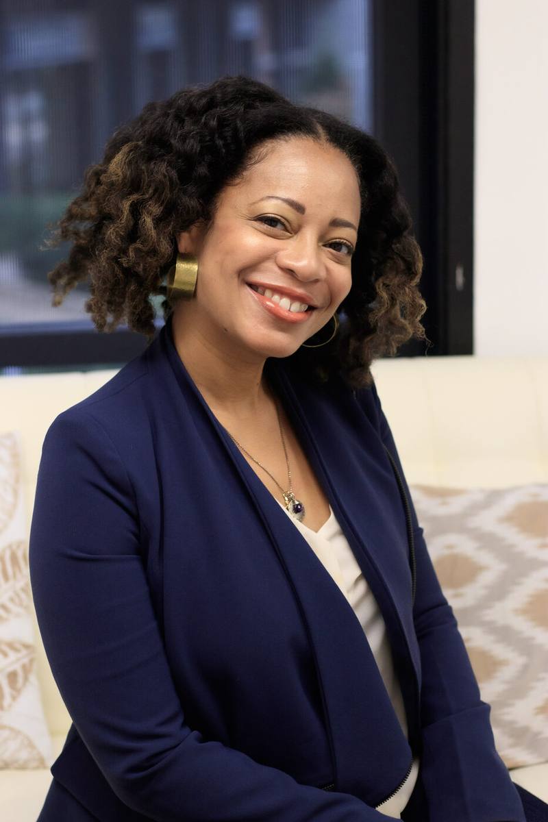 Leslie Holley seated on a sofa, smiling